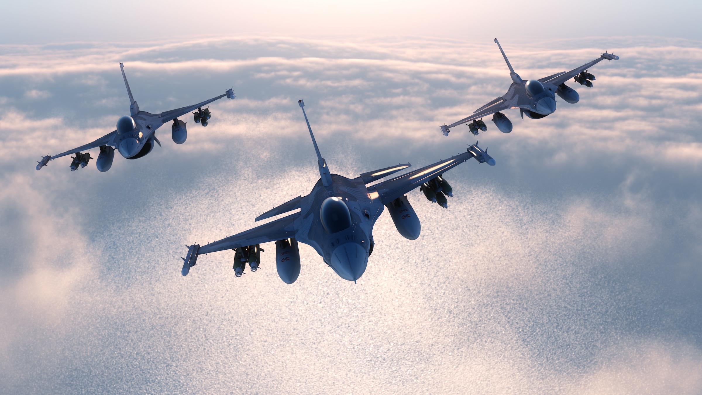 Three jet fighter airplanes airborne above the clouds.