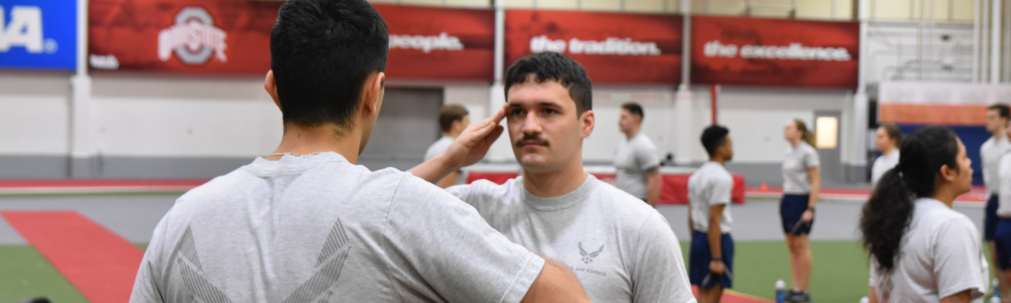 Cadets stand at attention in an Ohio State fieldhouse.