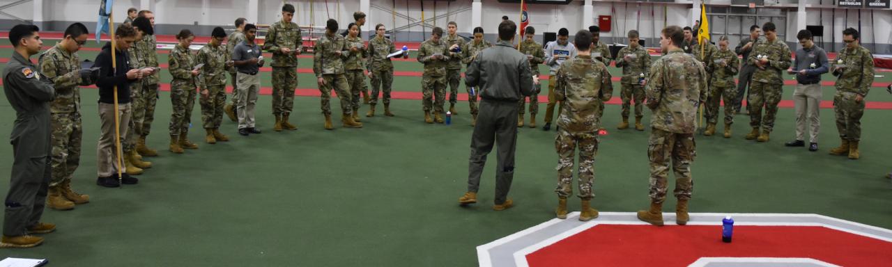 ROTC leadership speak with cadets in the Ohio State fieldhouse.